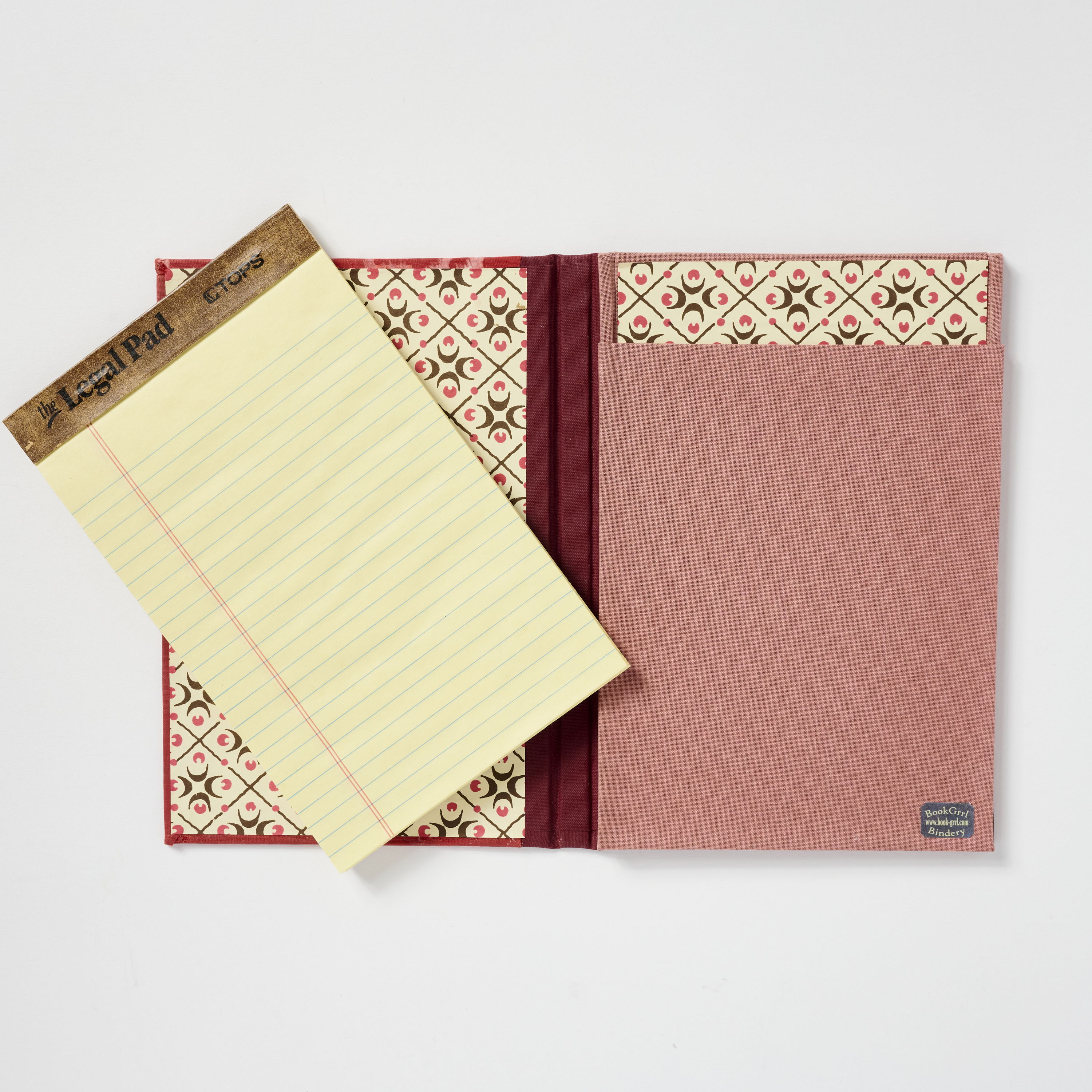 Open notebook with decorative inner cover and a notepad beside it.