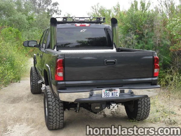 Rear view of Dean's black 2005 Chevrolet Silverado 2500 HD with vertical exhaust stacks and lifted suspension, install photo 3