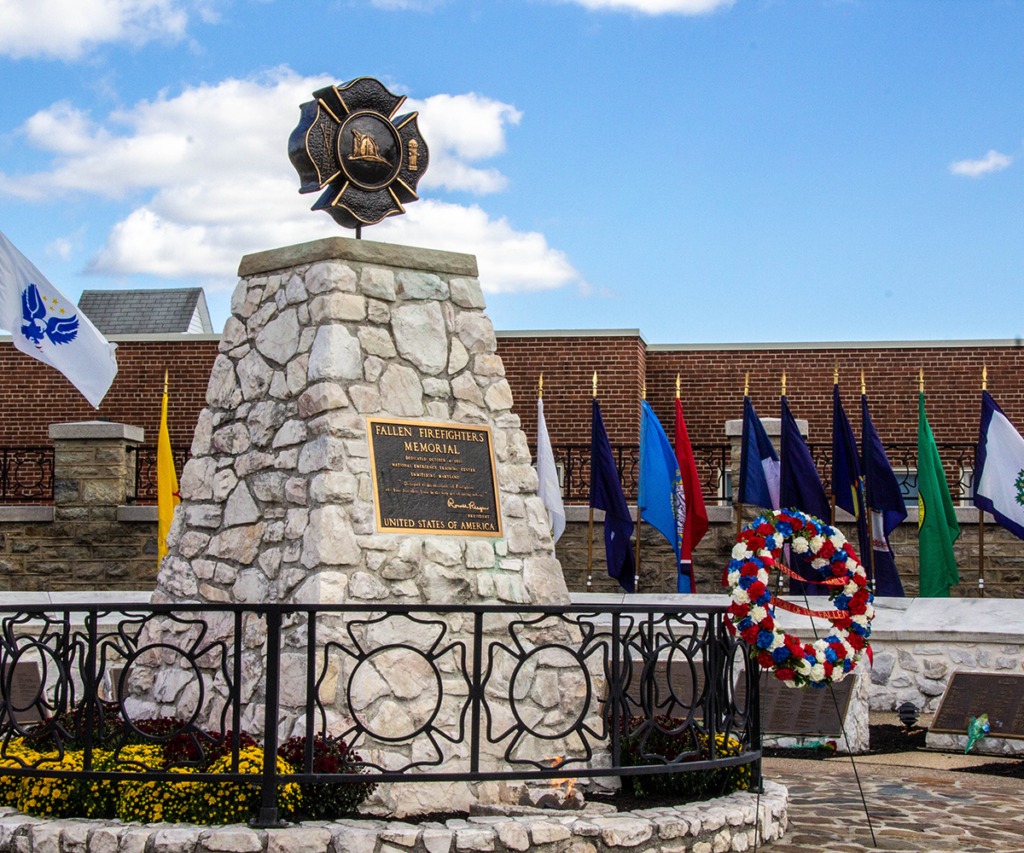 Stone monument with a bronze emblem and surrounding flags.