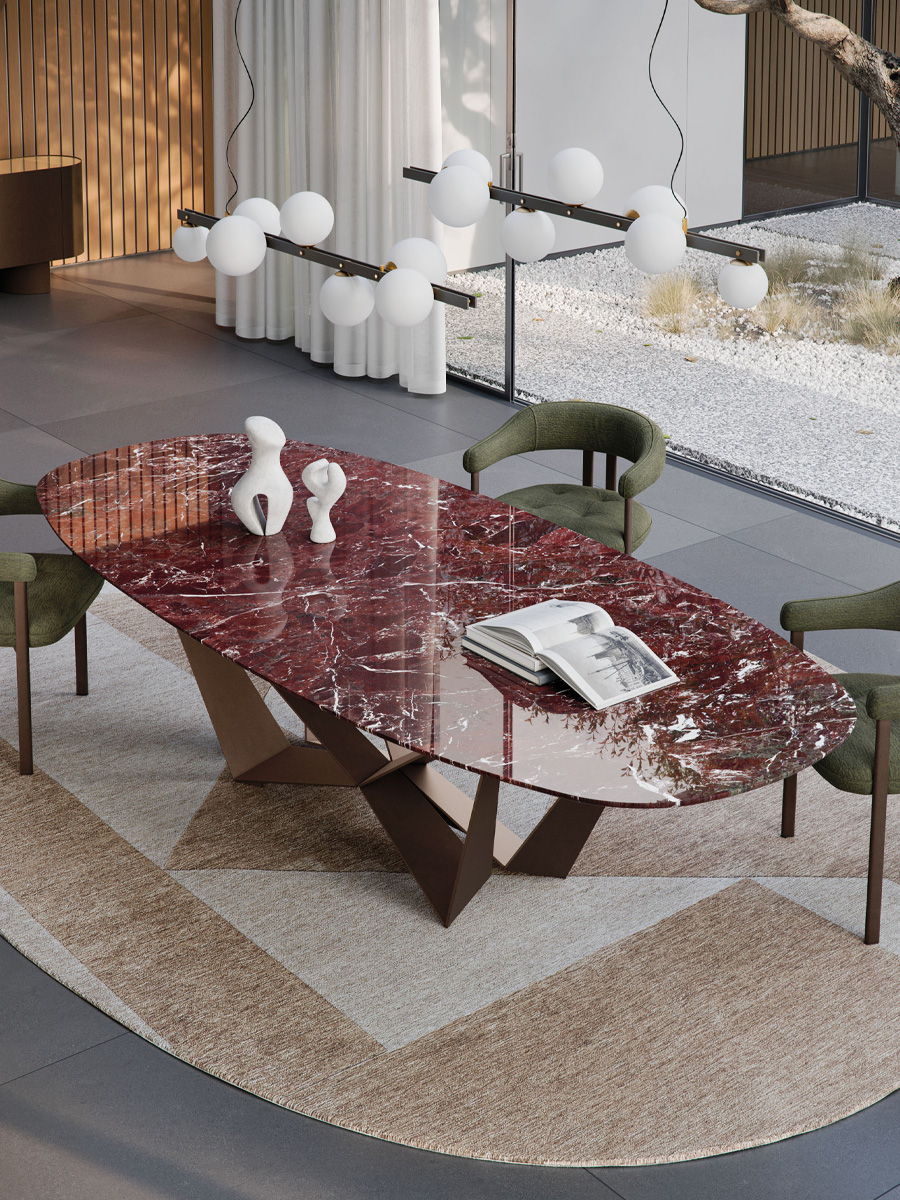 Modern Skorpio Marble dining table with a red marble top and stylish green chairs.