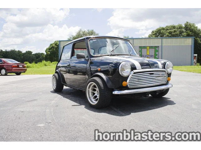 Front-three-quarter Chad's 1970 MINI Cooper classic compact car exterior grille round headlights chrome bumper Conductor's Special 844K Nightmare Edition train horn kit featured photo 1