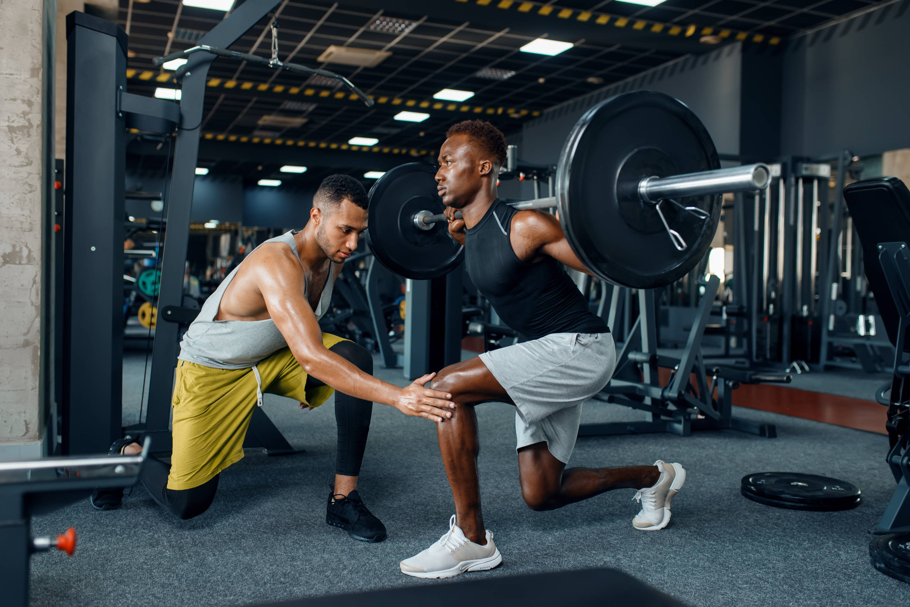 Man lifting weights. Man exercising with personal trainer