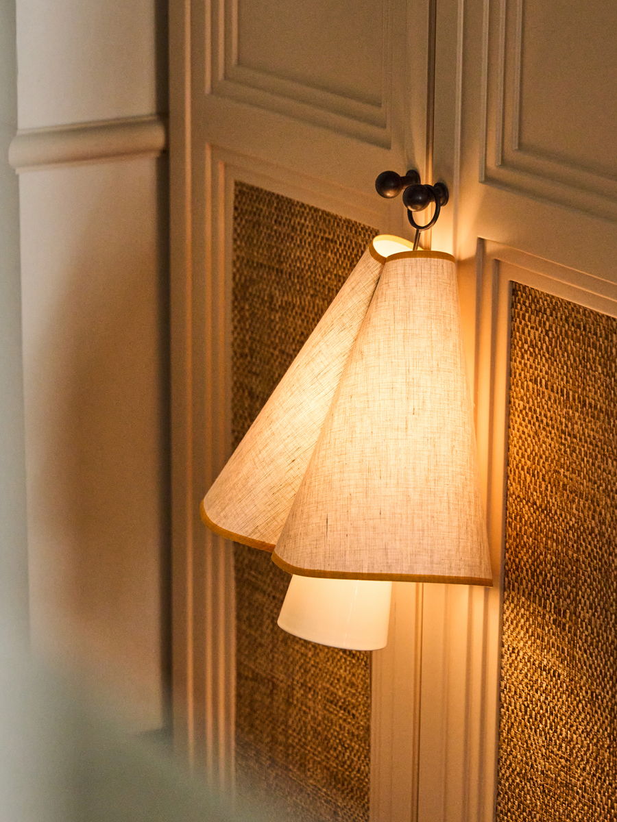 A glowing lamp with a cone-shaped shade on green grass.