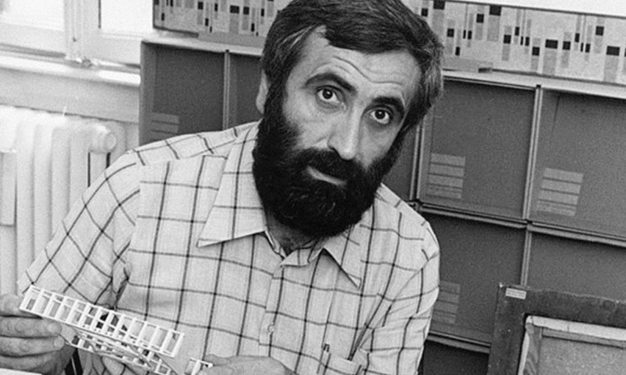 Enzo Mari in his studio holding design prototypes