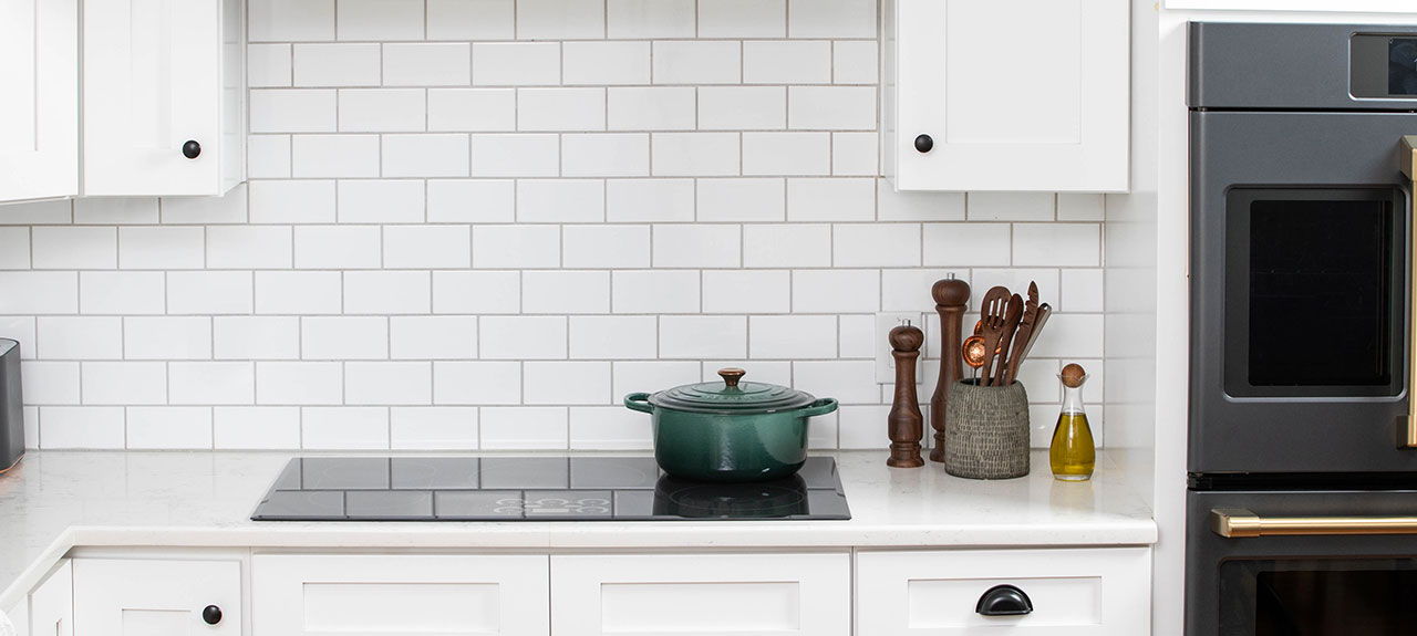 Cafe induction Cooktop with green pot, utensils, and olive oil.