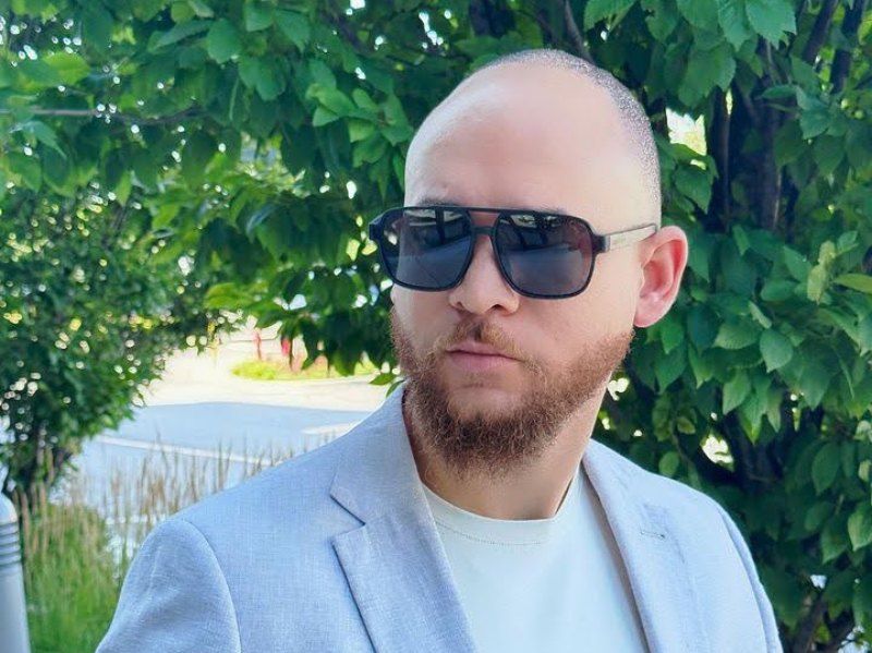 bald man wearing Parker, black oversized squared aviator sunglasses