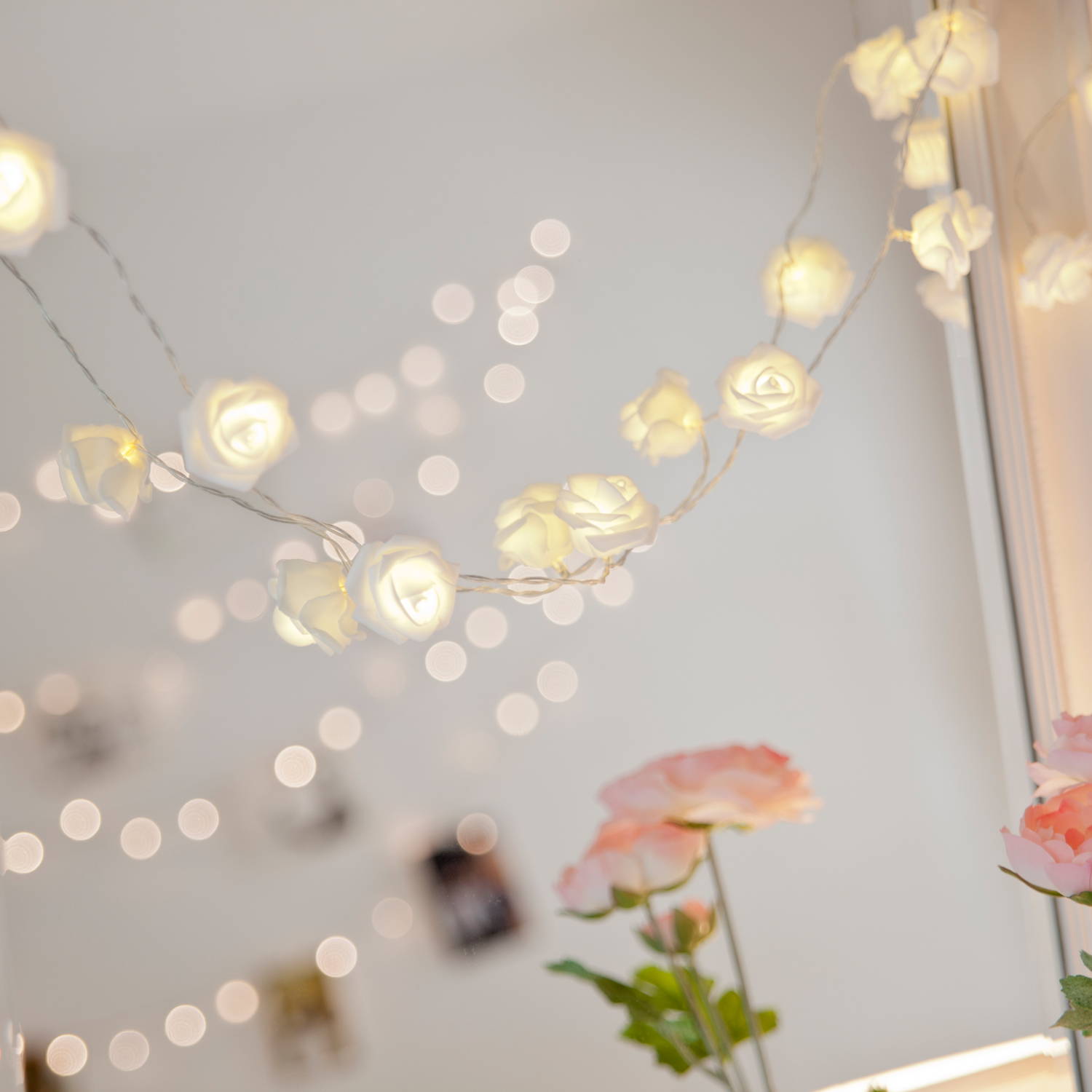 Rose fairy lights illuminated and draped across mirror