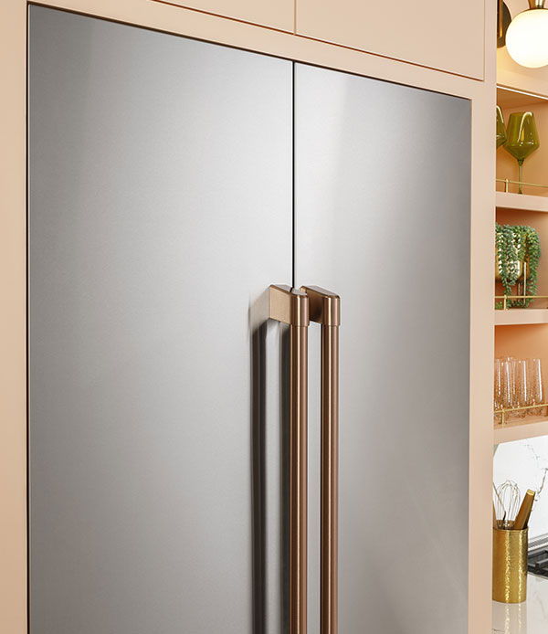 French-door stainless steel refrigerator with brushed copper handles.