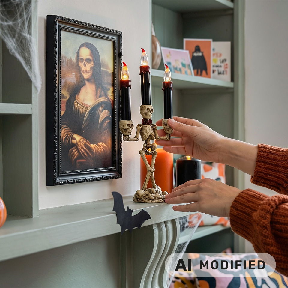 Une personne décore une étagère avec des bougies et des objets sur le thème d’Halloween.
