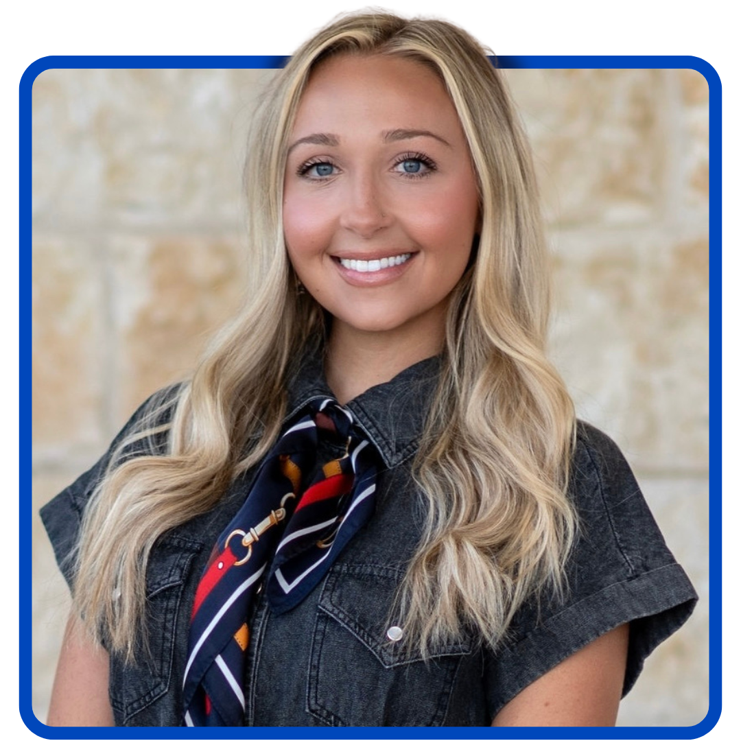 Smiling young woman with long blonde hair, wearing a denim shirt and patterned tie.