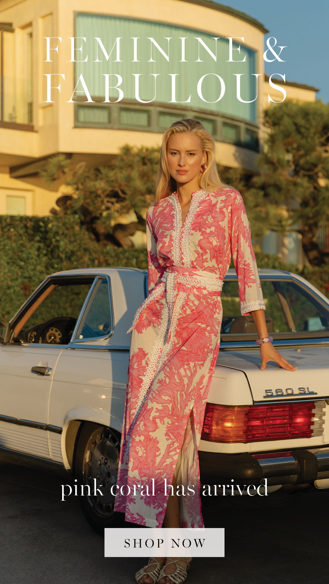 Model in pink dress next to a vintage car, promoting 