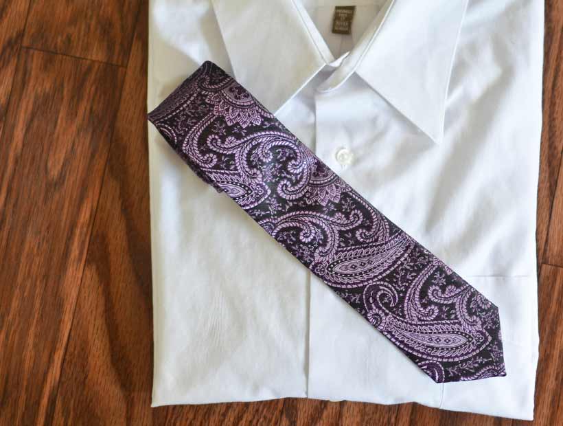 Purple paisley tie displayed on a white dress shirt