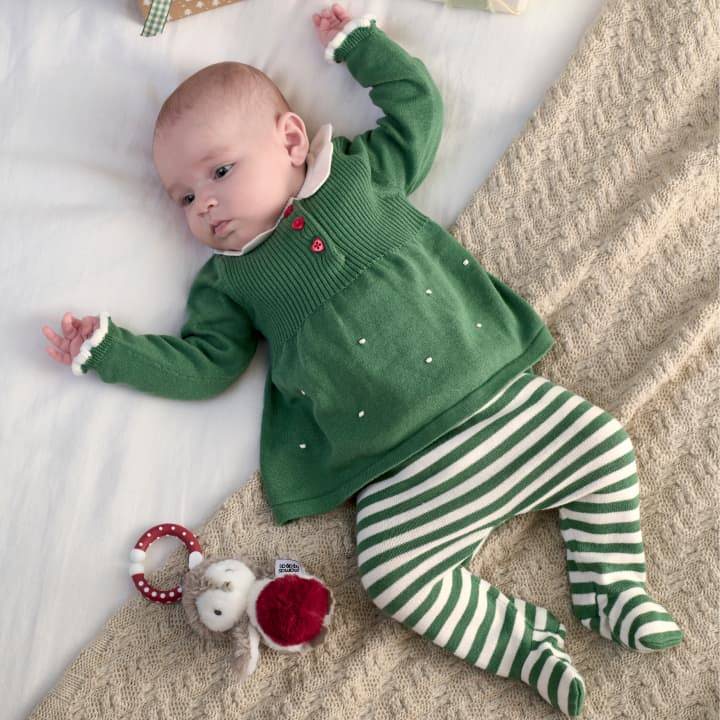 Baby wearing a green elf outfit