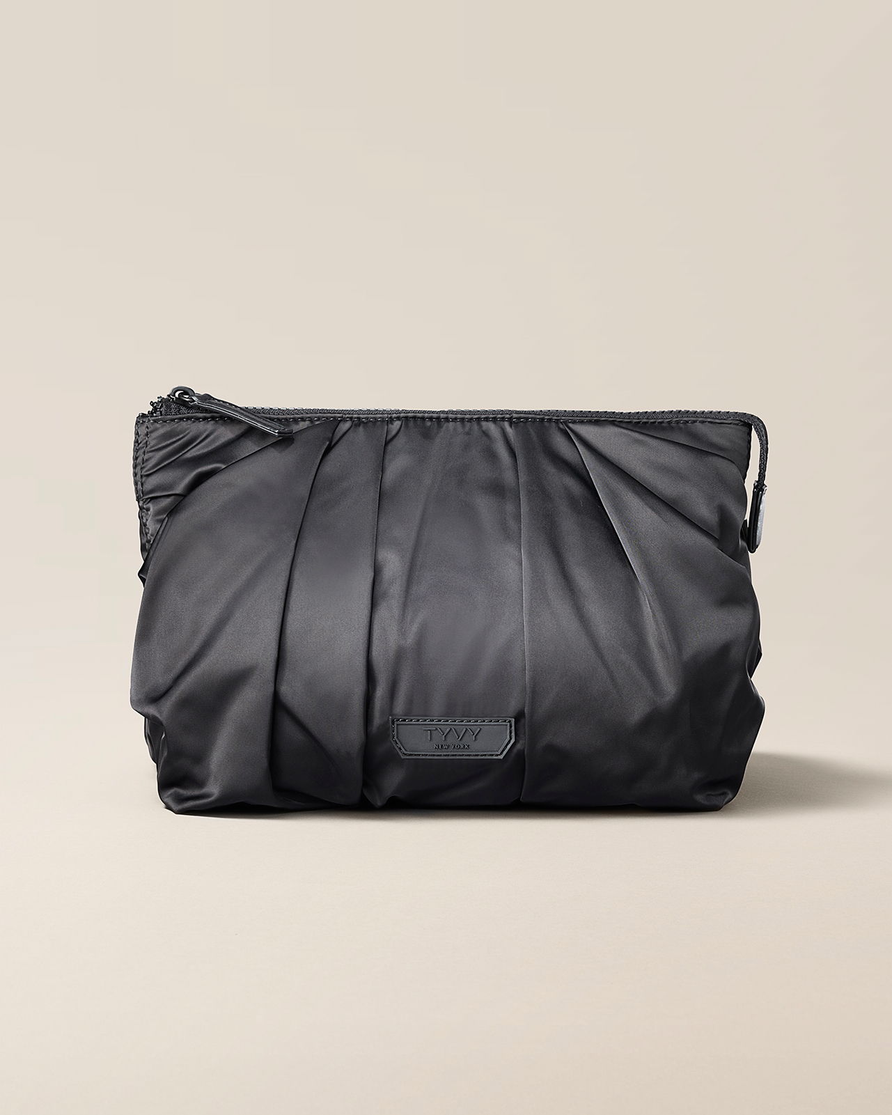 Black pleated pouch bag on a neutral background.