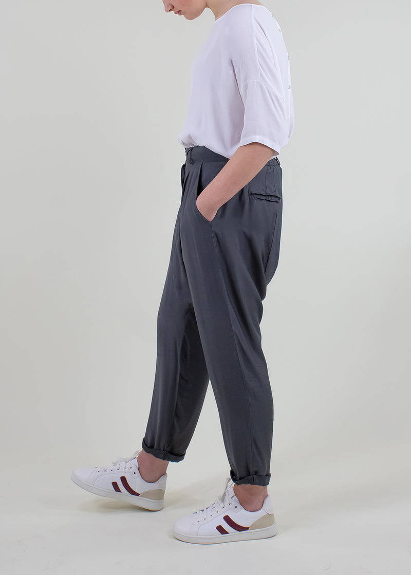 A model wearing a dark grey relaxed fit trousers 