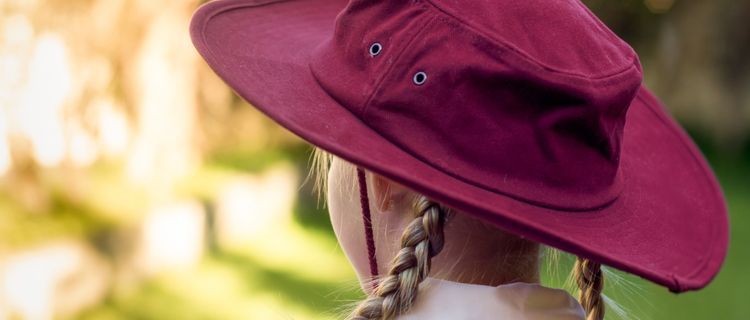 Student wearing maroon broad-brim hat outdoors