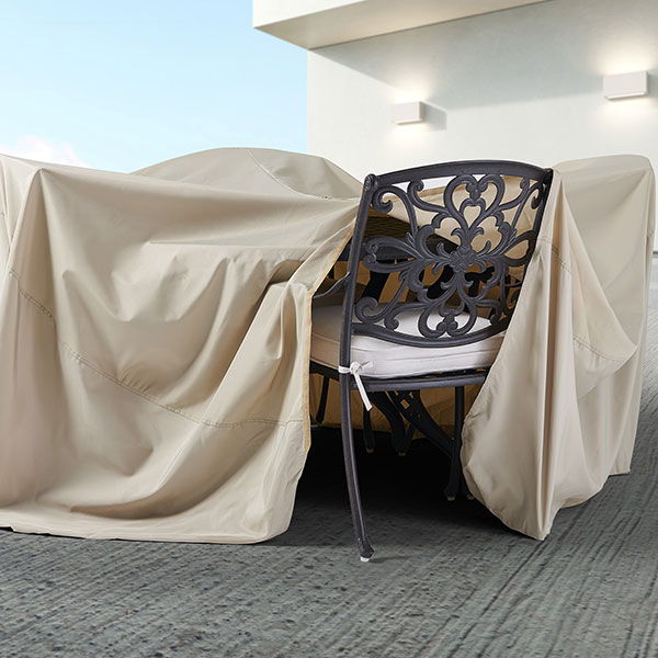 A chair covered with a beige protective cover on a patio.
