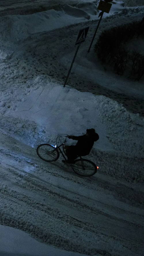 Person riding dynamo equipped Pelago on snow late at night