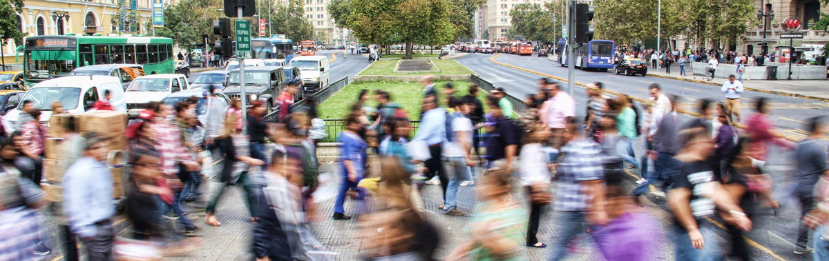 people walking across a busy street at a stop light