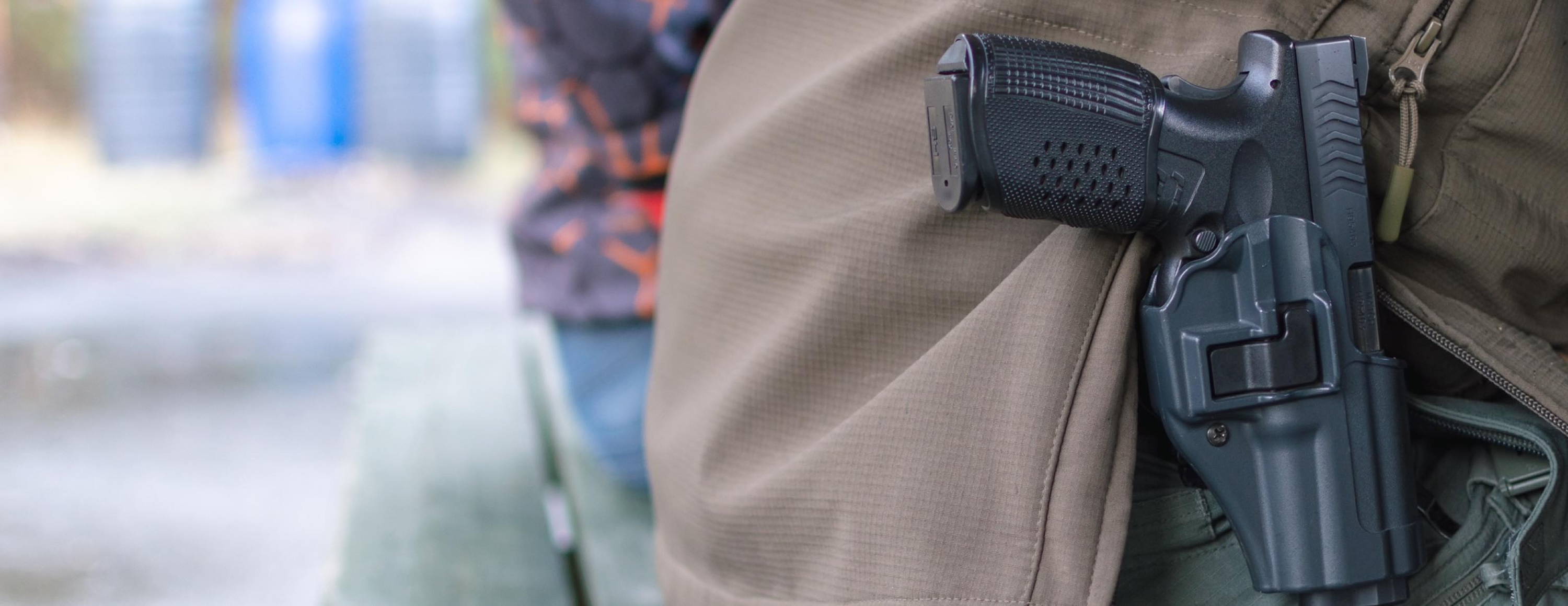 Man sitting on park bench with gun in open carry holster