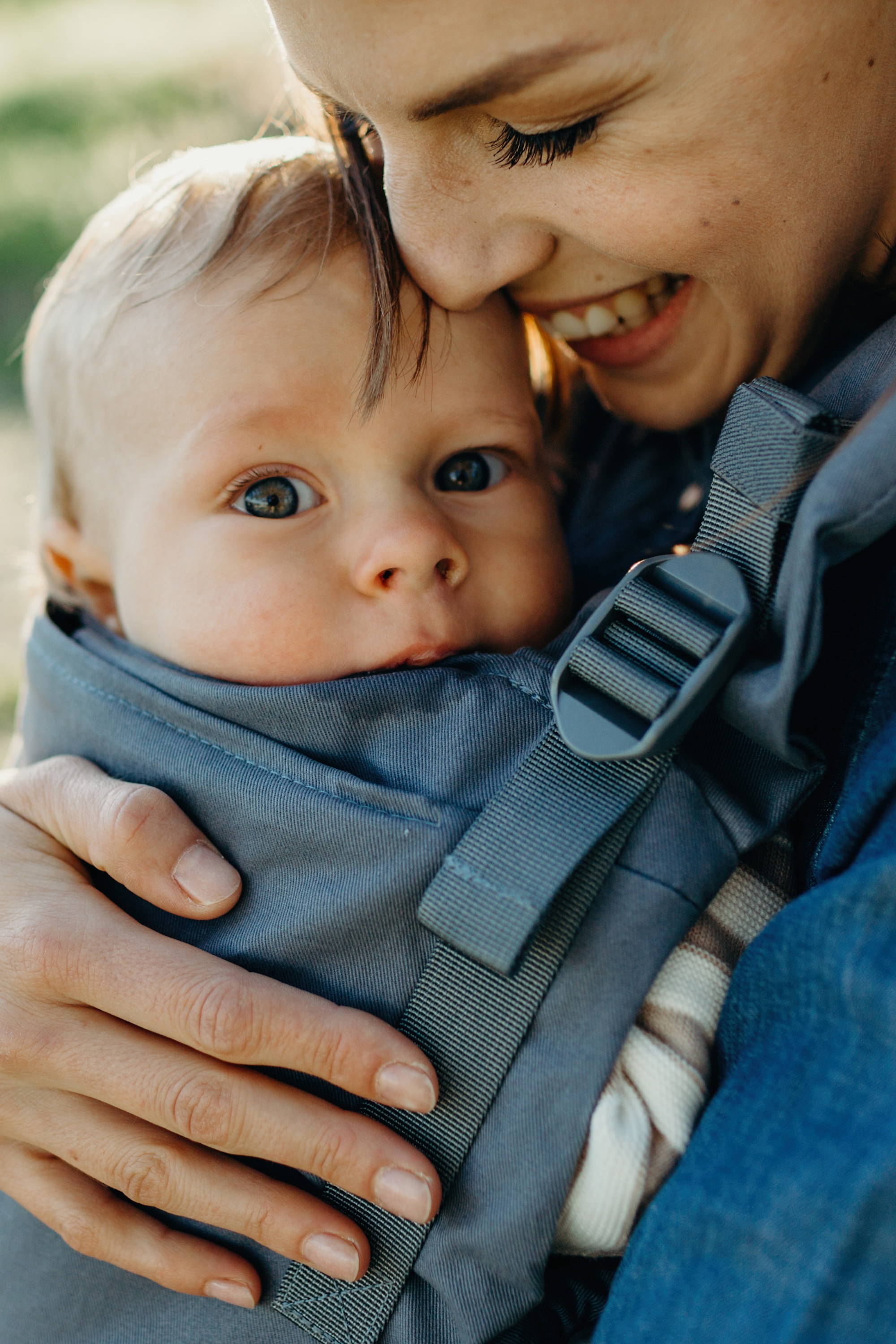 Happy mom snuggling her curious baby