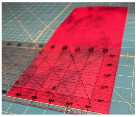 Close-up of 5.75-inch wide by 14-inch long red fabric strip on a cutting mat.