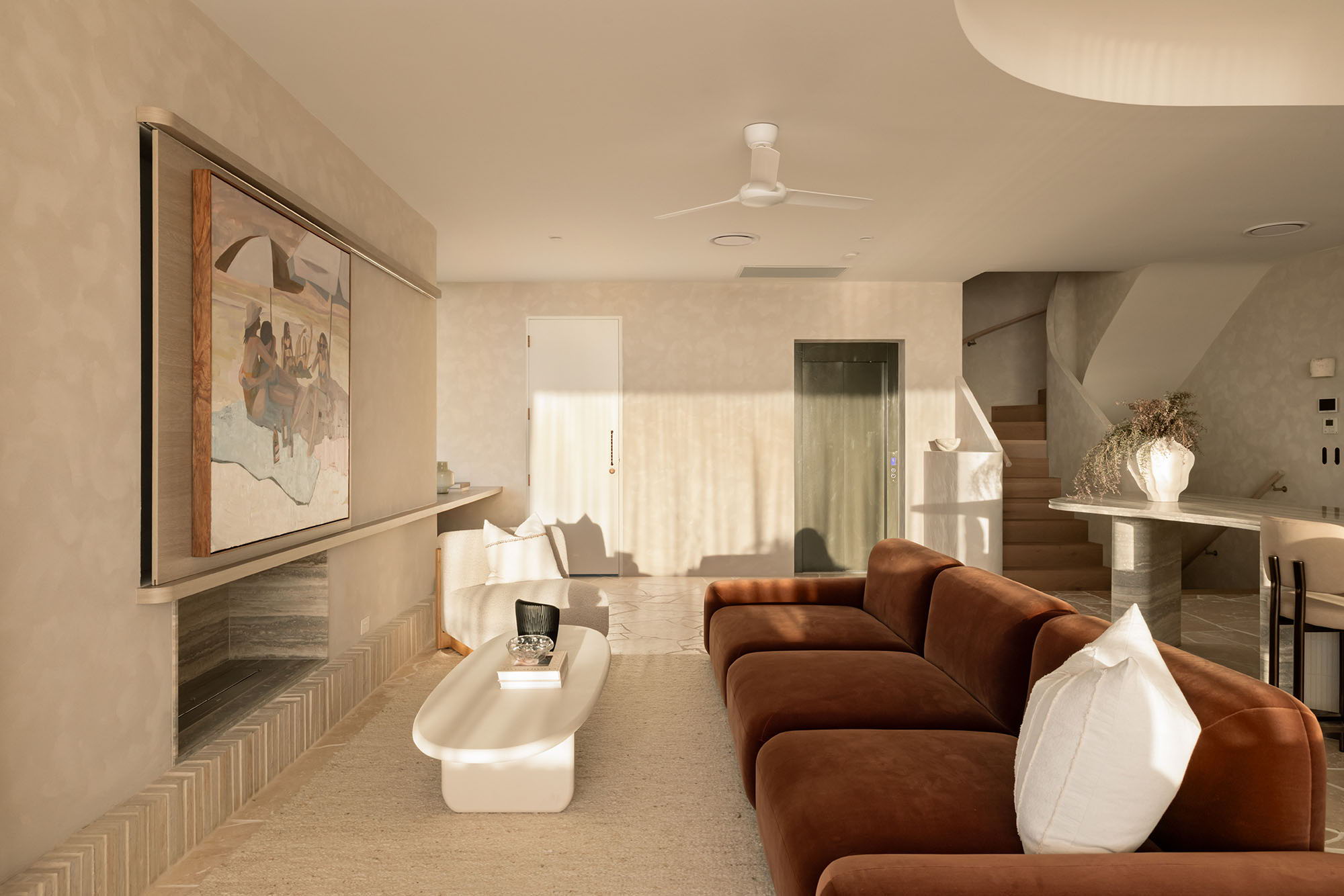 Modern living room with brown sofa, art, and dining area.