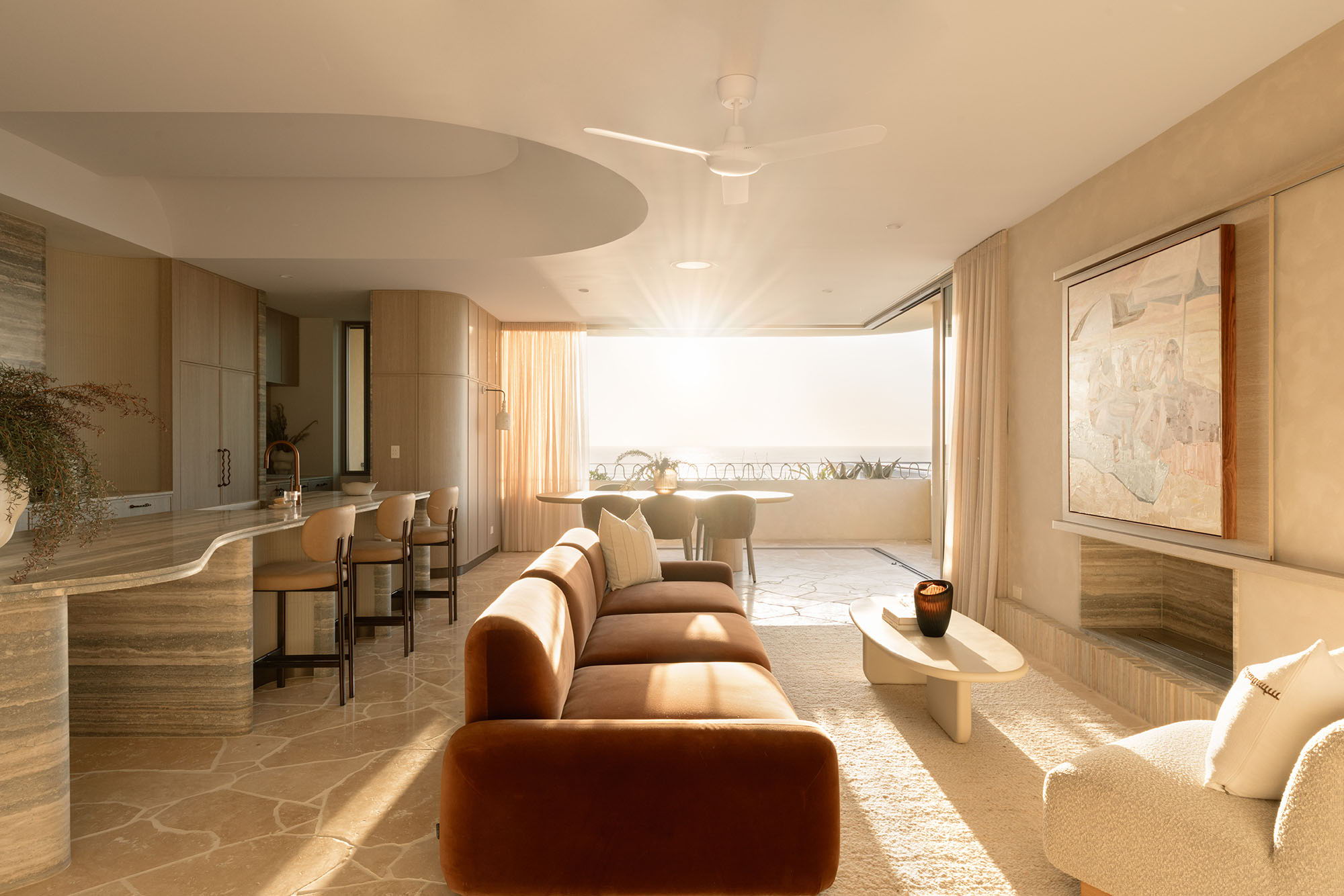 Modern living room with large windows, warm lighting, and the Fossil Coral Arc Dome Wall Light.