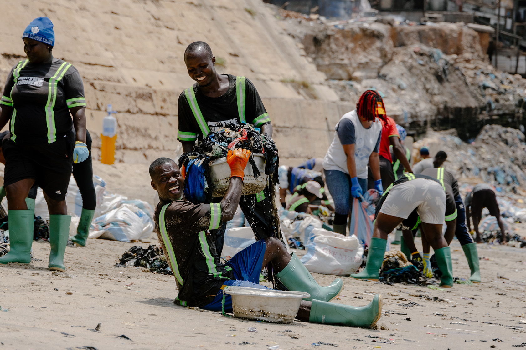 People cleaning up waste at a beach site.