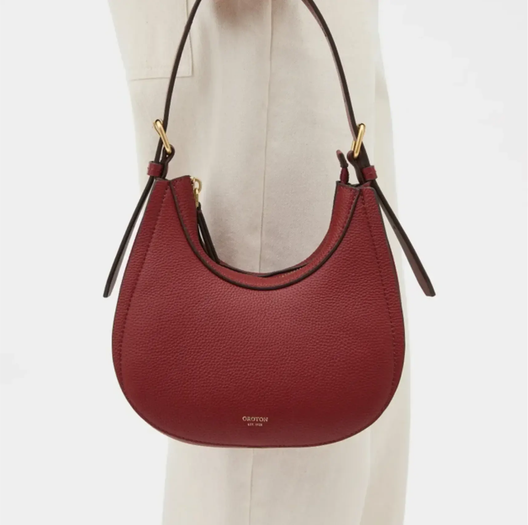 Red handbag with a curved shape and shoulder strap.