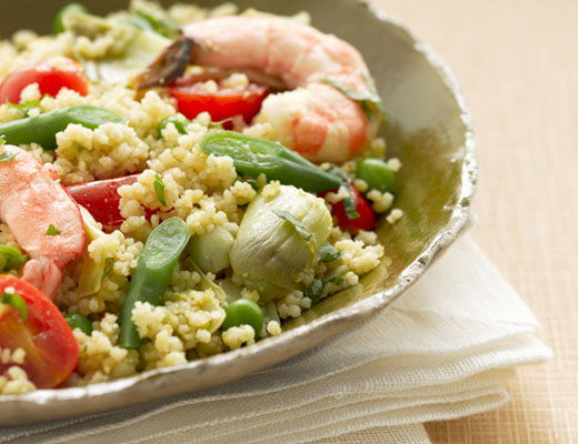 A bowl of couscous with shrimp and vegetables.