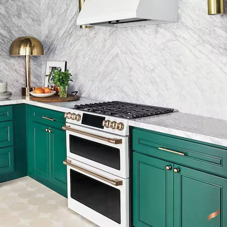 Gas matte white range in kitchen with bright green cabinets
