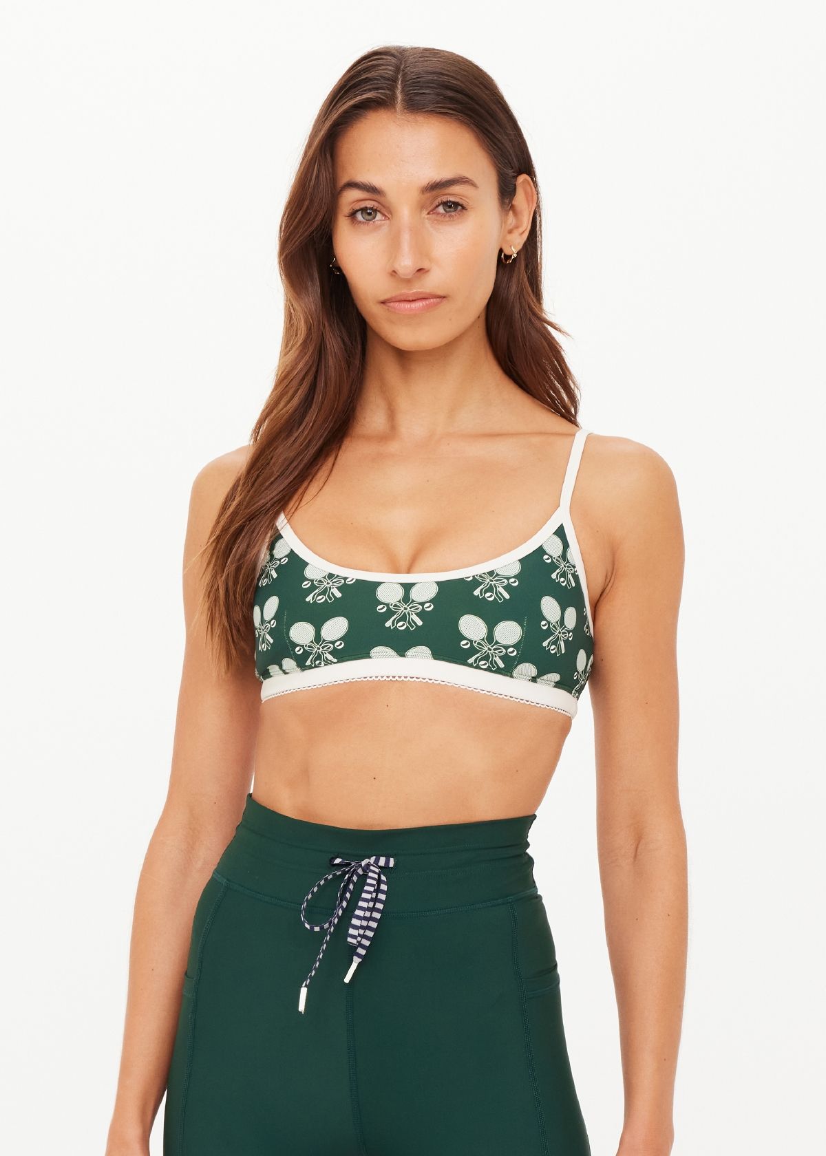 Model wearing a floral-patterned bralette and high-waisted green pants.