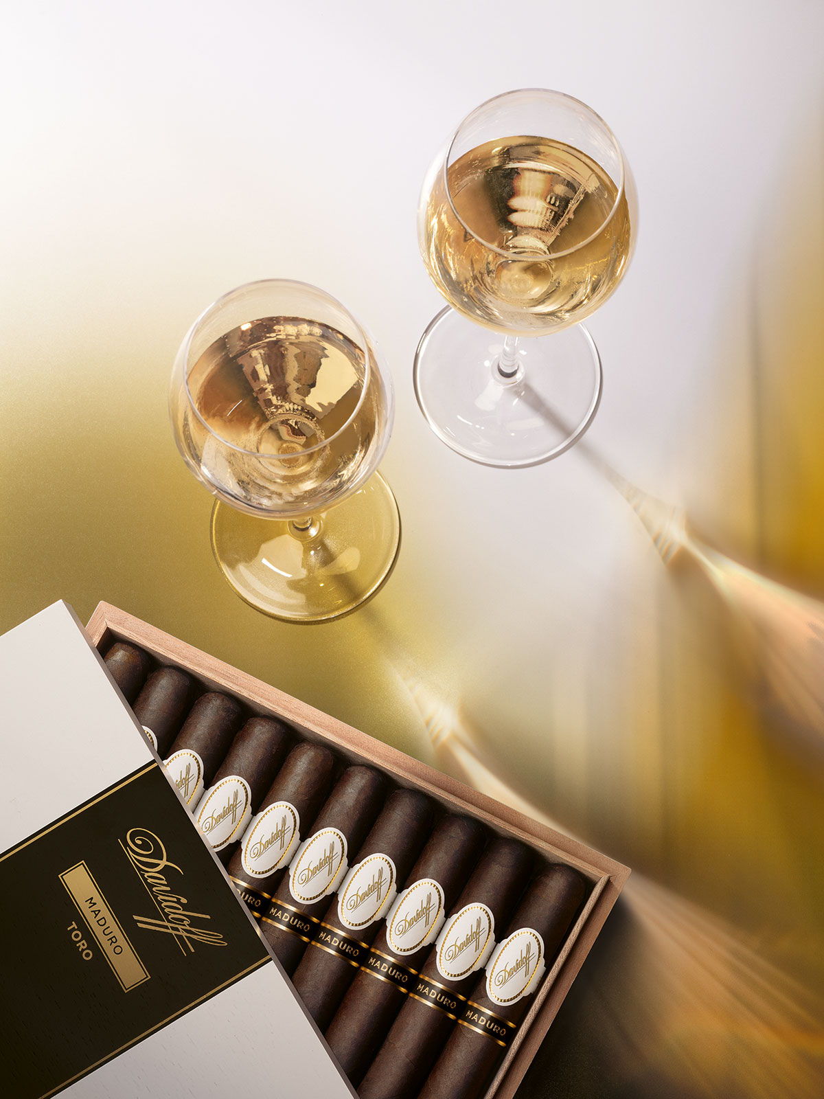 Opened box of the Davidoff Maduro Toro next to two glasses filled with ice wine.