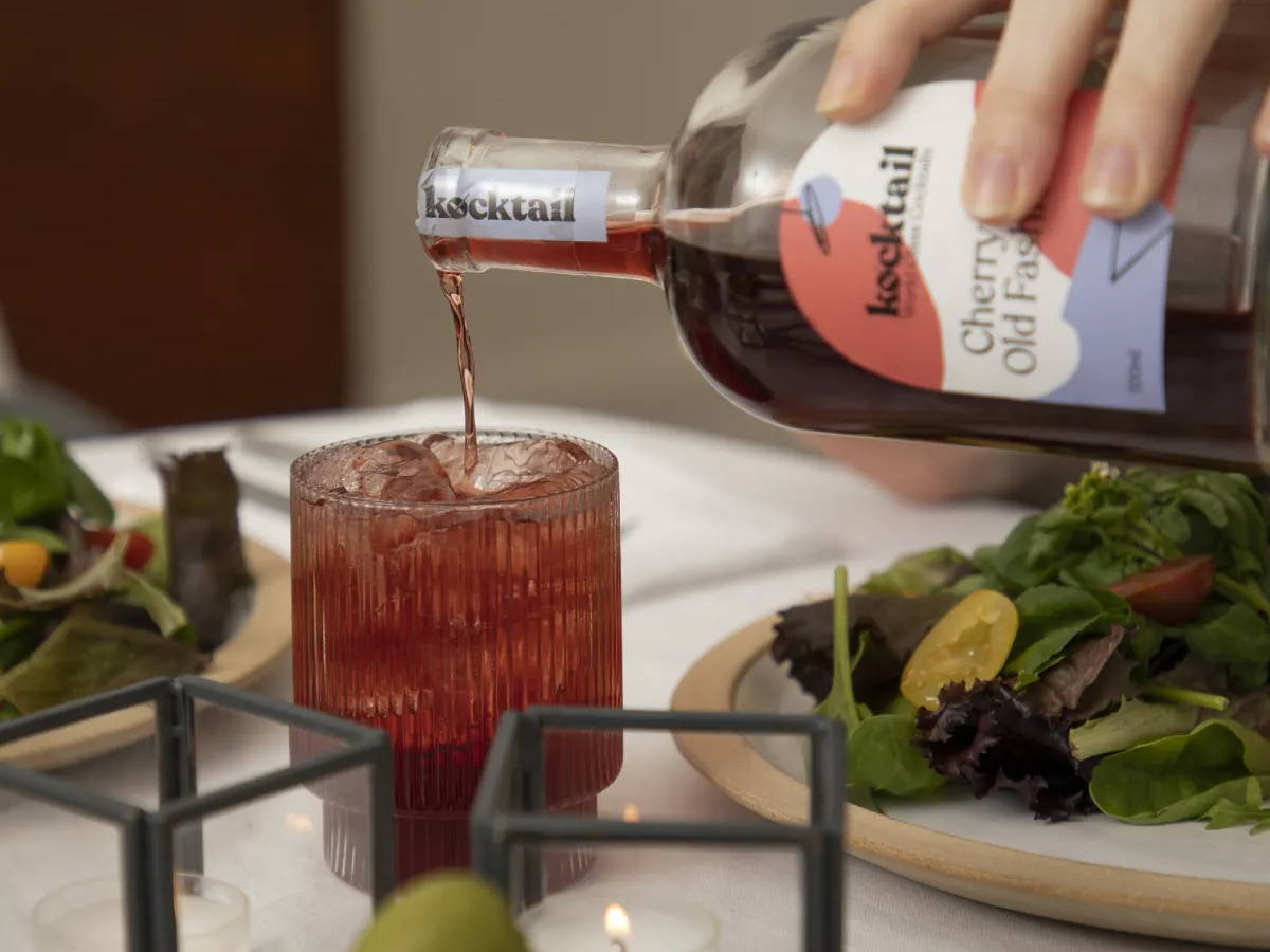 Cherry cola old fashioned being poured into a glass