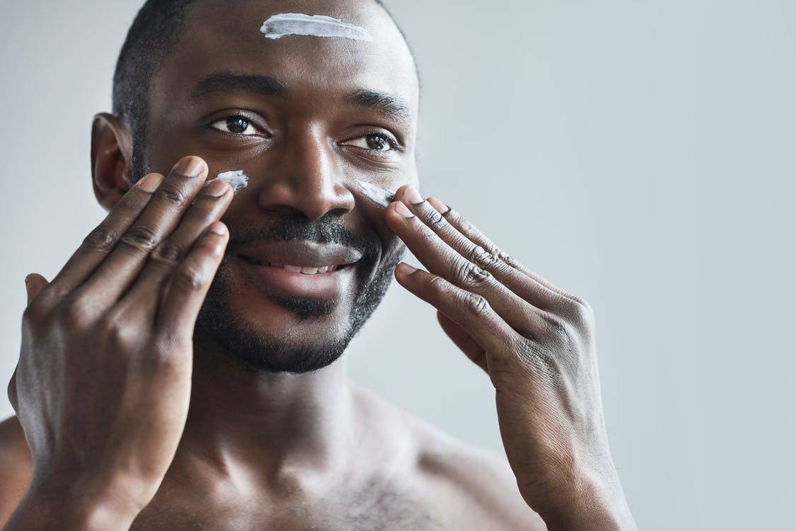 a black guy with man face cream on his face