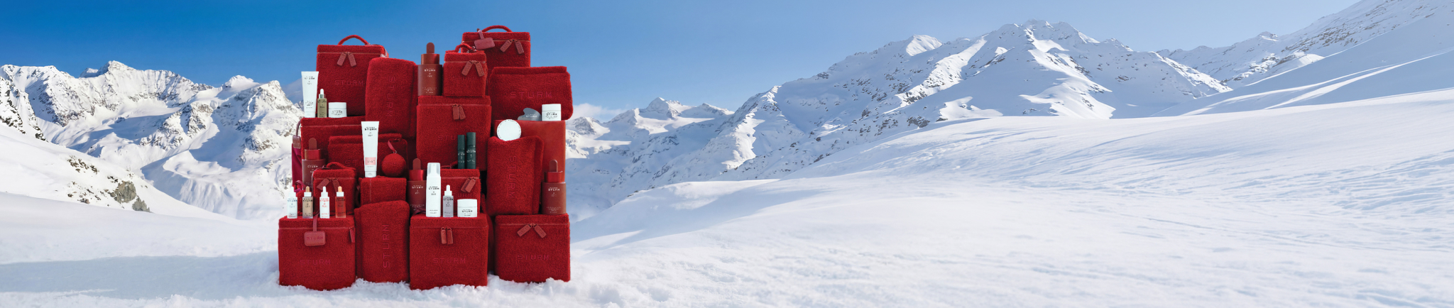 Red packages in a snowy landscape with mountains in the background.
