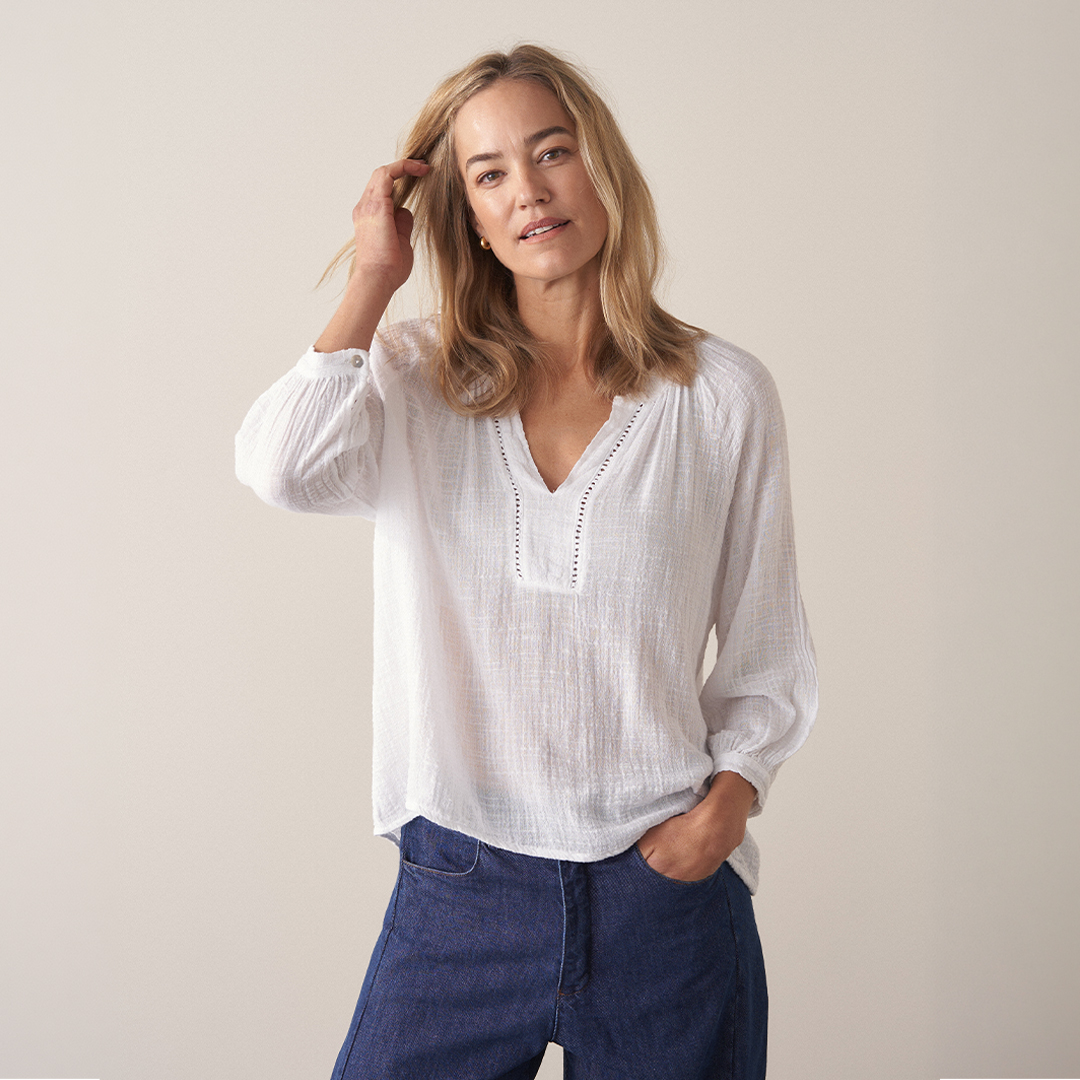 Woman wearing a white cotton top with blue denim trousers