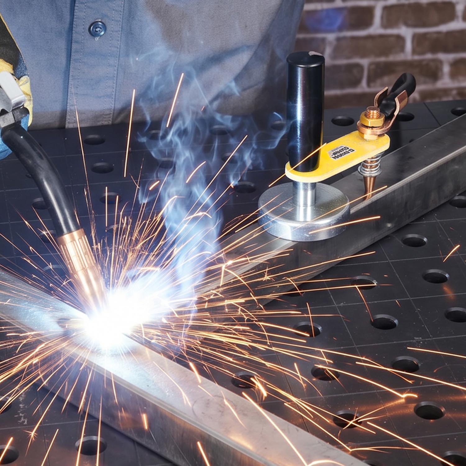 Welding process with sparks and smoke on a work table.