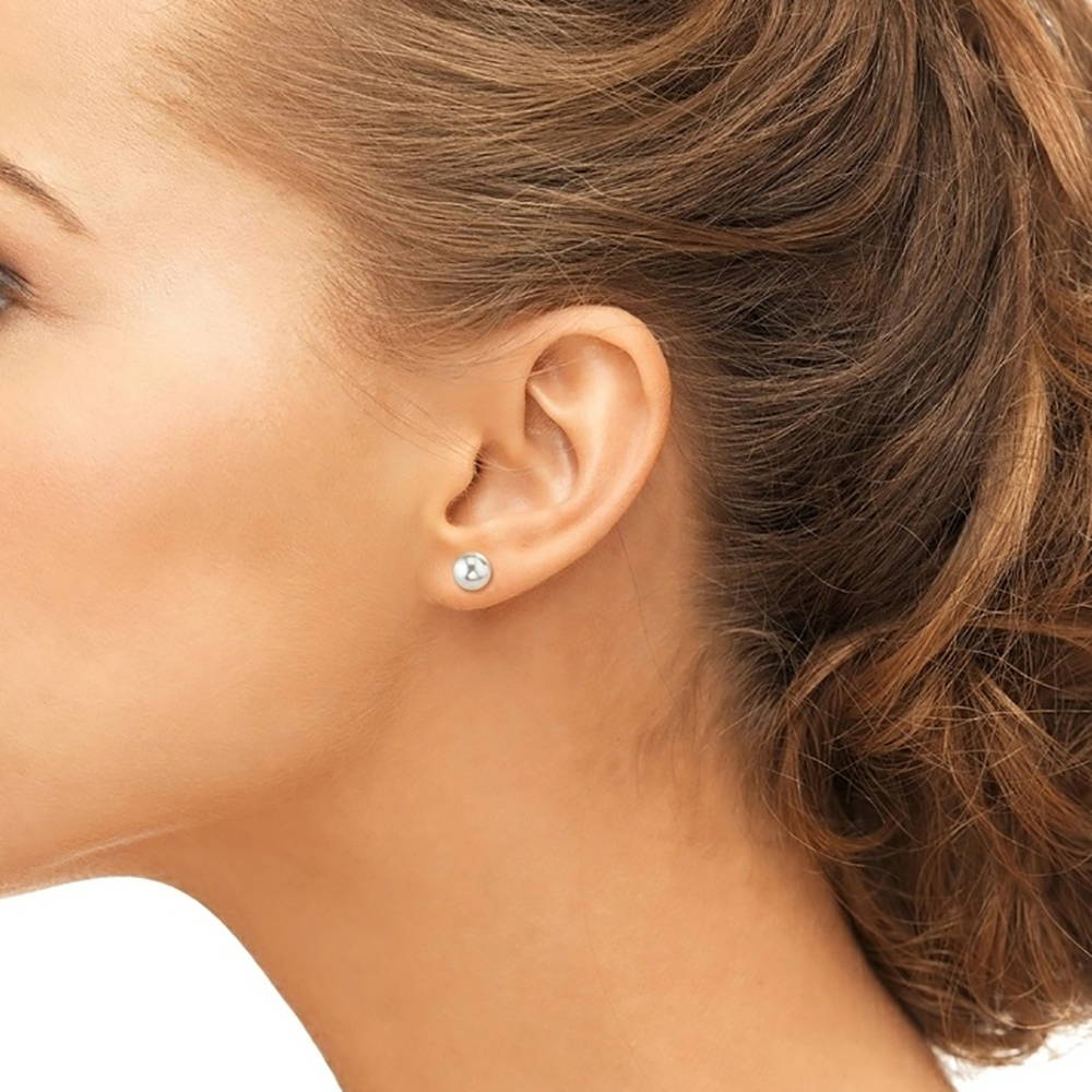 Model wearing a small pair of pearl stud earrings