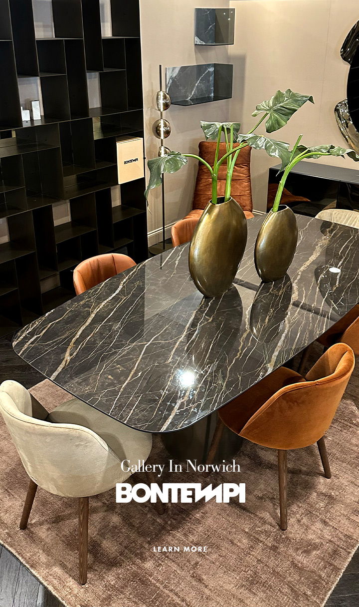 Modern dining table with decorative vases and stylish chairs in a gallery setting.