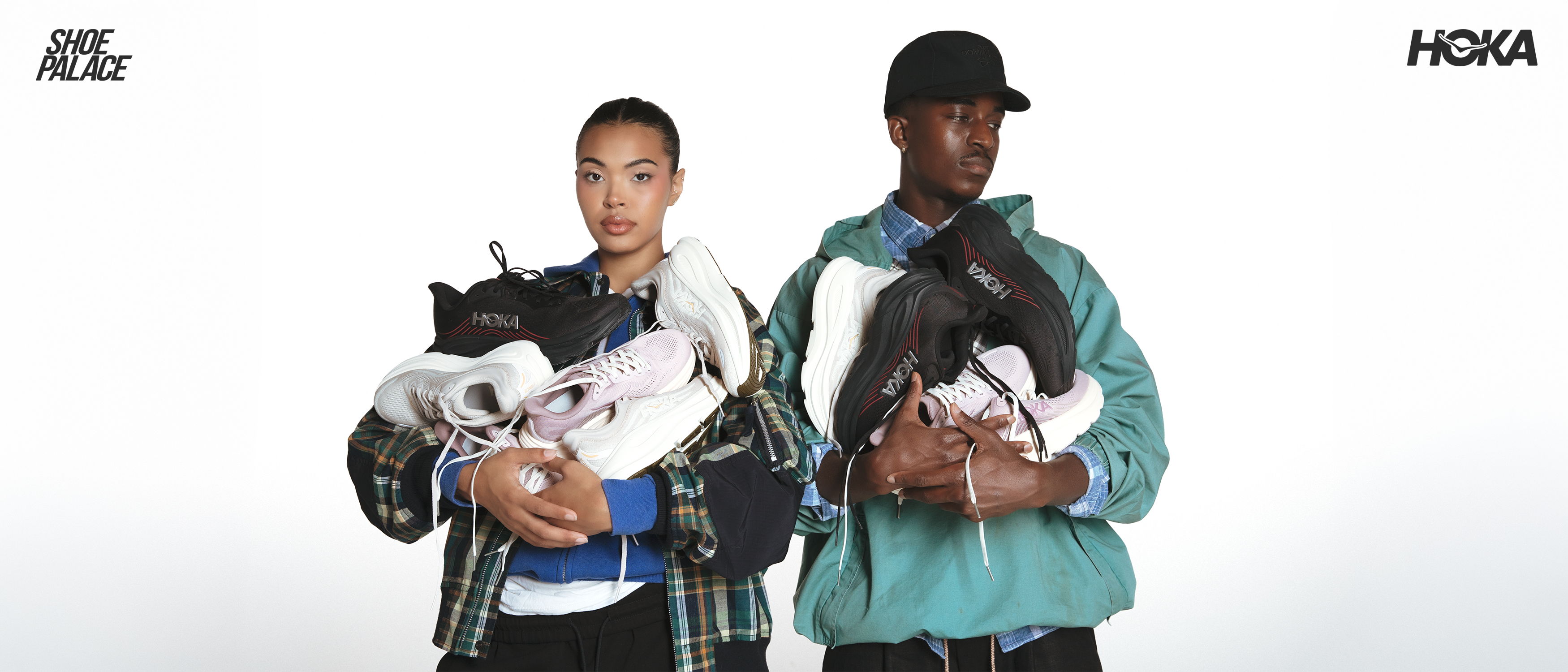 Two people holding dogs against a plain background.