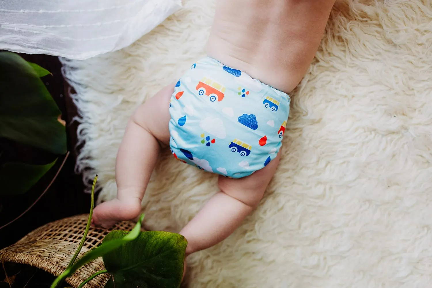 Dreaming baby wearing the planes and trains print from Simple Being Cloth Diapers. Looking simply comfortable in his reusable diapers.