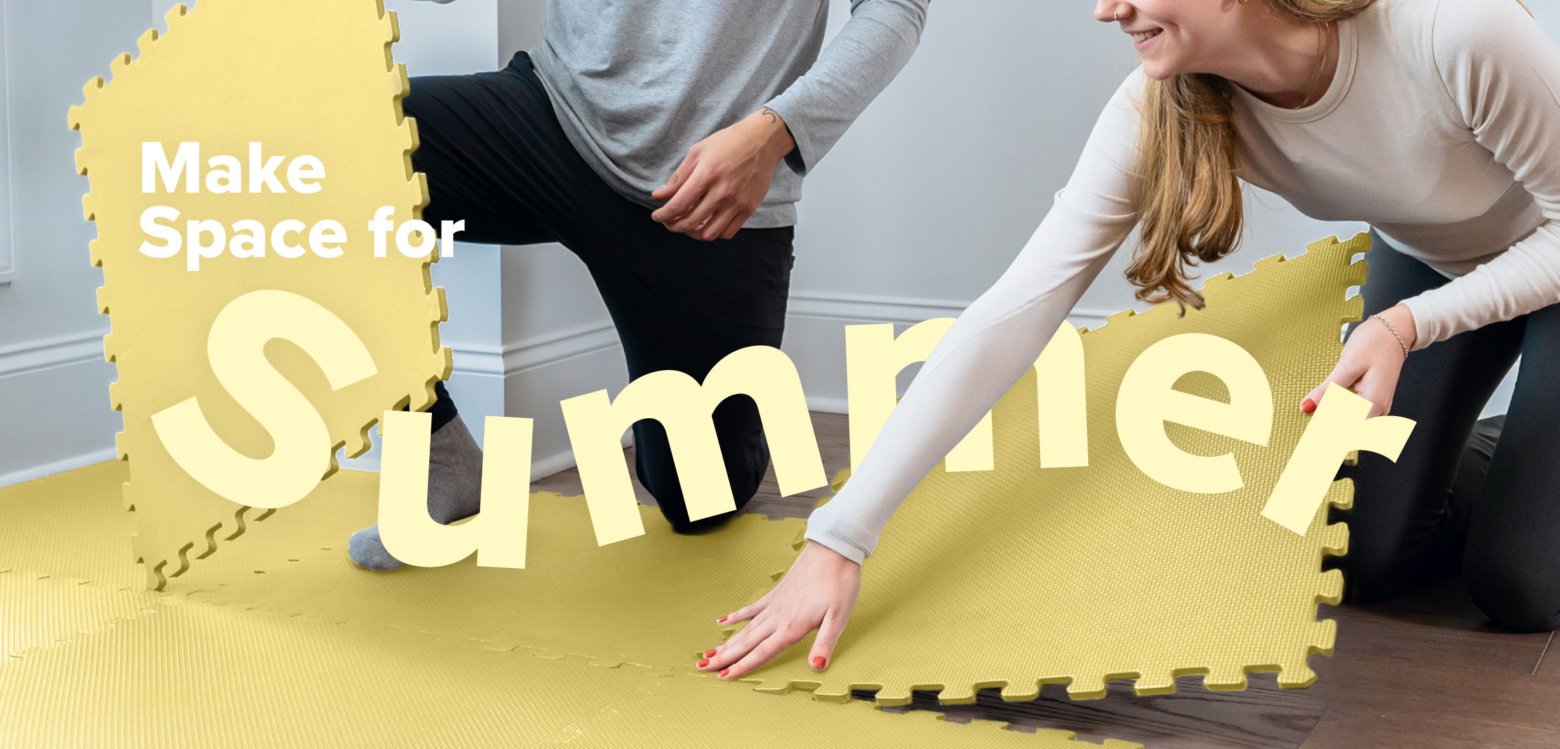Two people laying yellow floor mats with text 