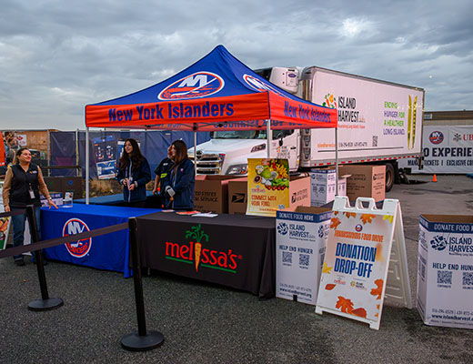 Food event booth with tents, tables, and promotional materials.