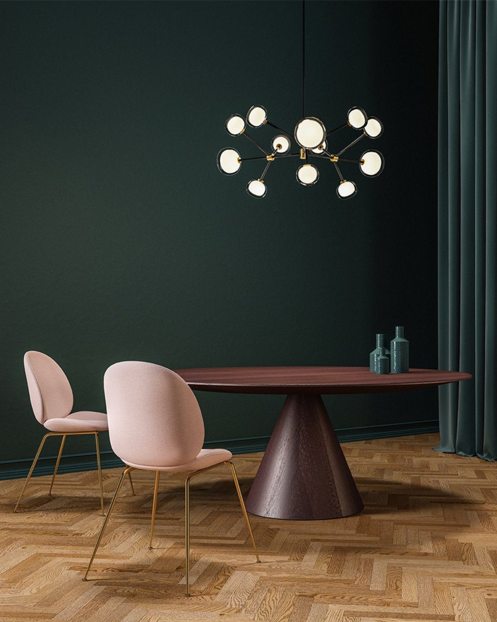Modern dining room with pink chairs, wooden table, and a chandelier.