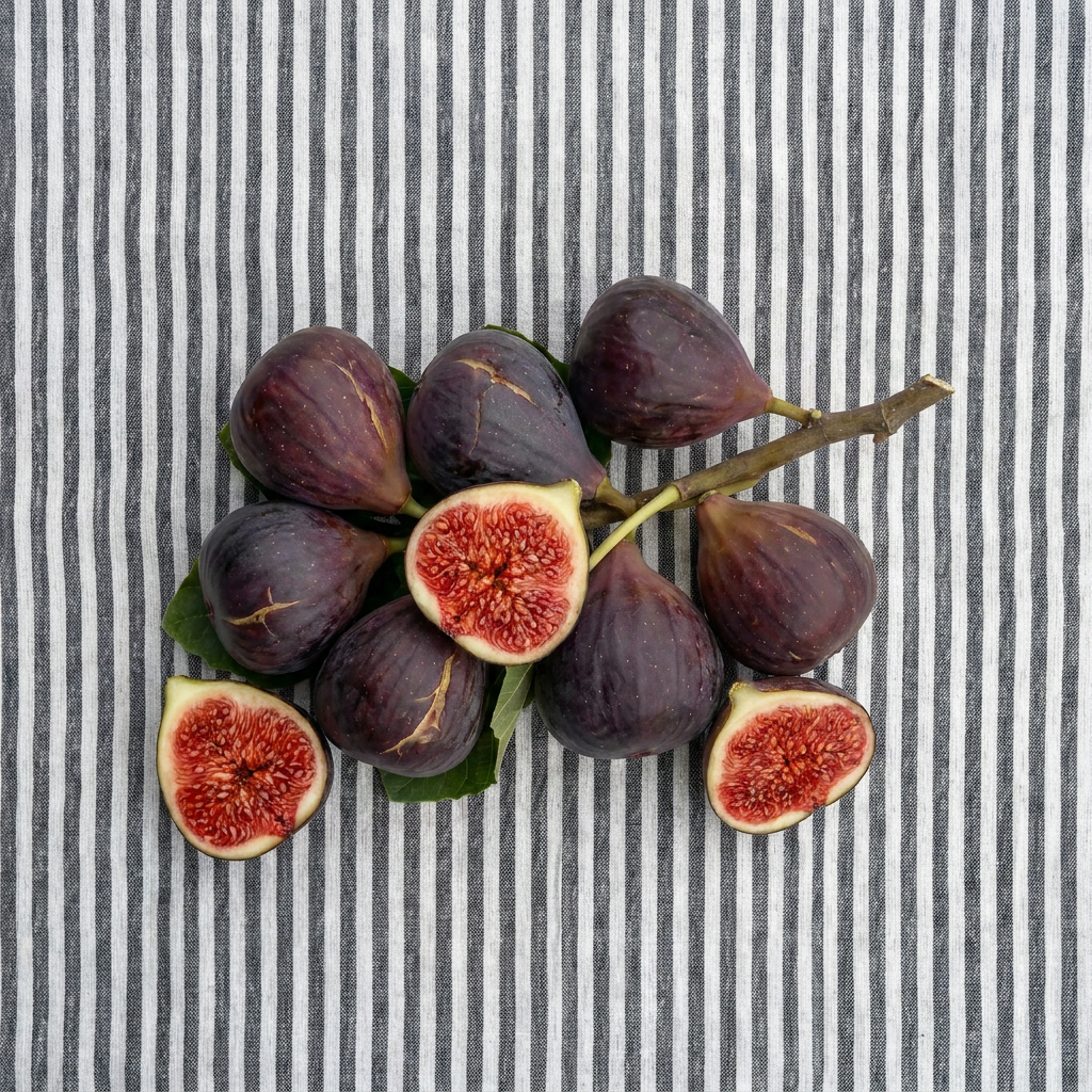 Fresh figs on a striped background, some cut in half.