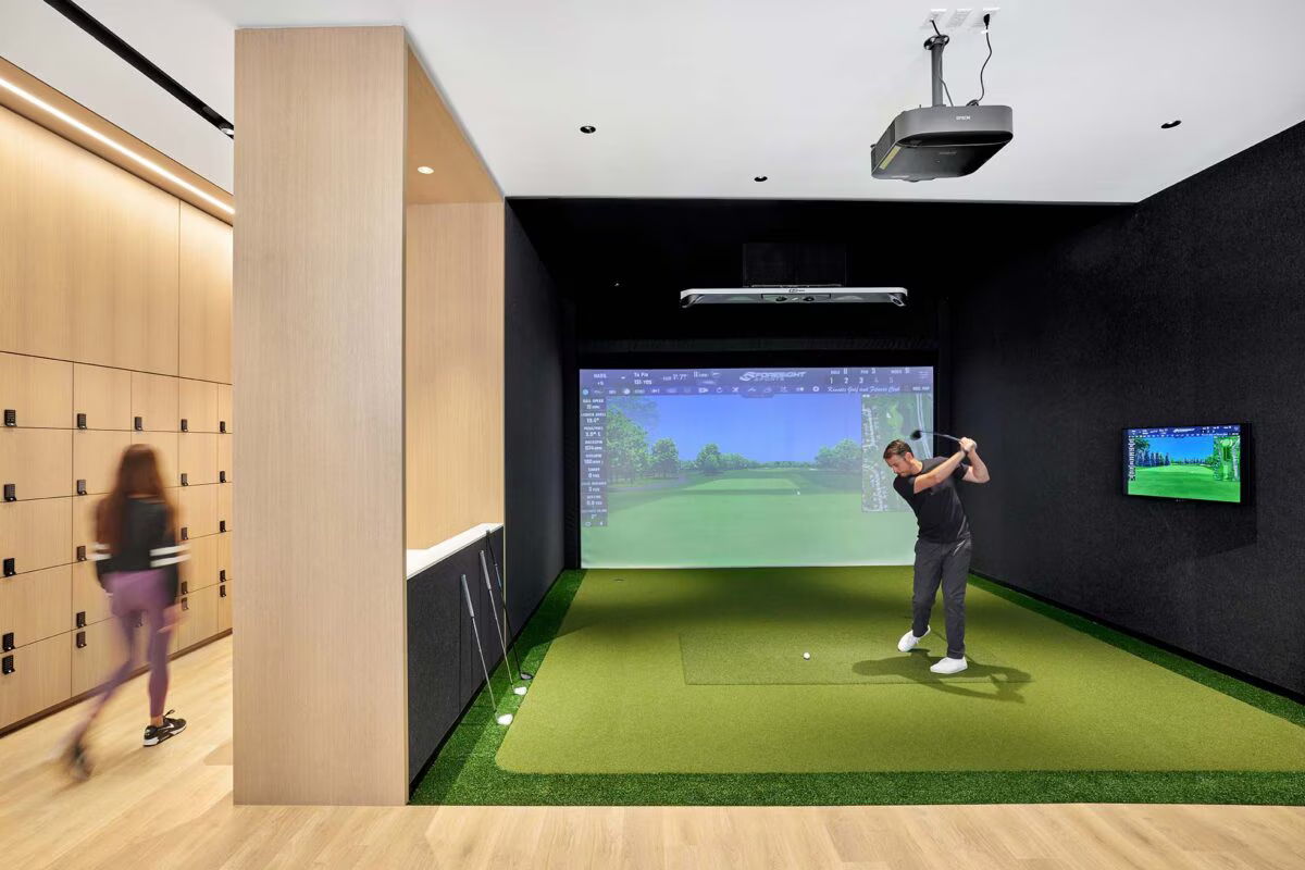 Person playing golf in a virtual golf simulator room.