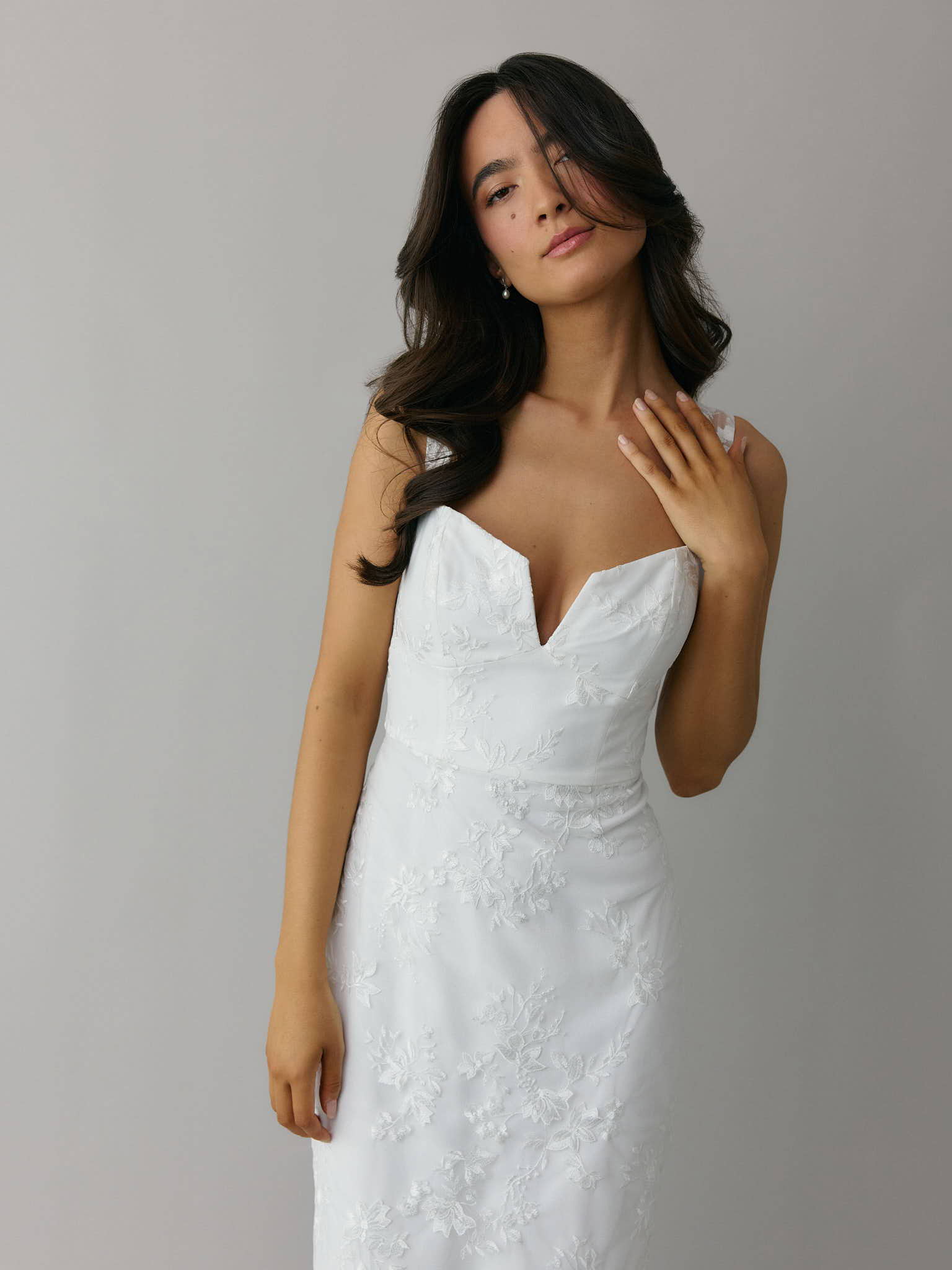 Girl wearing mini satin bridal event dress in Ivory with drop waist and scooped neckline with draped fabric. 
