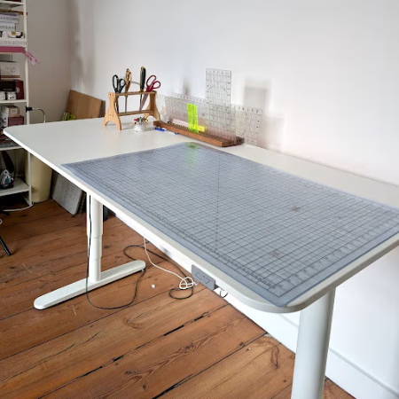white cutting table for sewing with cutting tools and a large cutting mat